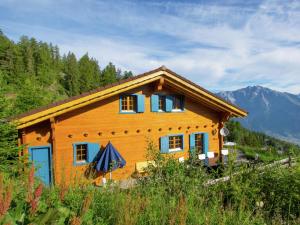 uma casa numa colina com montanhas ao fundo em Chalet Alpina offers great views em La Tzoumaz