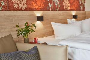una camera d'albergo con due letti e un tavolo con una pianta di Feriendorf Rerik a Rerik