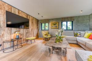 un salon avec un canapé et une table dans l'établissement Gite 1 Maison Caerdinael - Gîte 14 personnes sur les hauteurs de Durbuy, à Durbuy