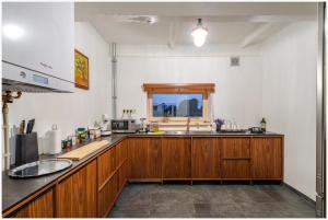 una cocina con armarios de madera y fregadero en Vintage Pilot's house - Pūpoli, en Nākotne