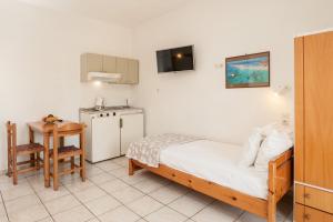 a small bedroom with a bed and a small table at Niriis Hotel in Kato Daratso