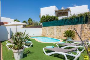 a villa with a swimming pool and lawn chairs at Nikydan in Cala d´Or