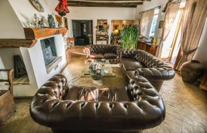 a living room with two leather couches and a fireplace at Le Murelle Country Resort in Manciano