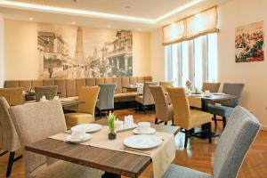 a restaurant with tables and chairs and a picture of the eiffel tower at Hotel Inselhof Borkum in Borkum