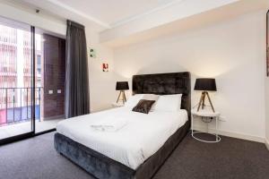um quarto com uma cama grande e uma janela grande em Subiaco Rooftop Terrace - EXECUTIVE ESCAPES em Perth