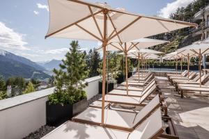 una fila de mesas y sombrillas en el techo de un edificio en NIDUM - Casual Luxury Hotel en Seefeld in Tirol