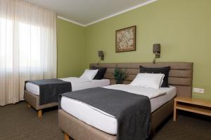 2 camas en una habitación de hotel con paredes verdes en Spa Hotel Ezeri, en Sigulda