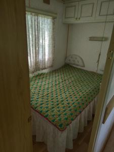 a small bedroom with a bed in a room at Luodžių dvaras in Salakas