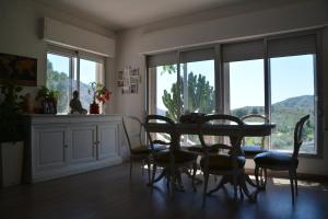 a dining room with a table and chairs and windows at CHALET CON PISCINA A 1 KILOMETRO DE LA PLAYA CARTAGENA in Cartagena