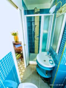 y baño azul con lavabo y ducha. en Napoli naif en Nápoles
