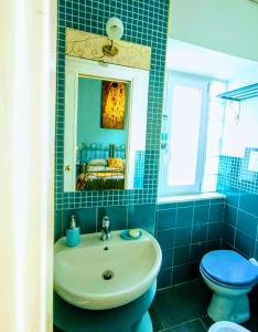 baño de azulejos azules con lavabo y aseo en Napoli naif, en Nápoles
