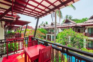 a balcony with a red table and two chairs at Railay Village Resort in Railay Beach