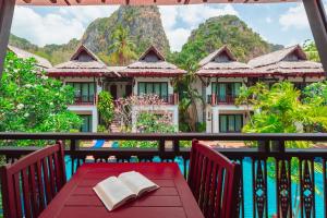 a table on a balcony with a view of a resort at Railay Village Resort in Railay Beach
