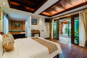 a bedroom with a large white bed and a bathroom at Railay Village Resort in Railay Beach