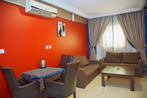 een woonkamer met een bank en een tafel bij NOUBOU INTERNATIONAL HOTEL BONAPRISO in Douala