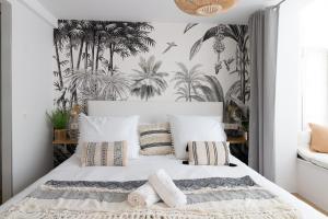 sypialnia z białym łóżkiem i tropikalnymi tapetami w obiekcie Bilbao Art Lodge Staynnapartments w mieście Bilbao