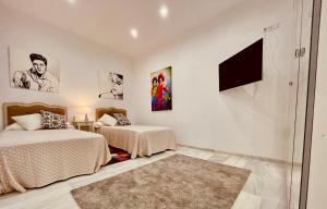 ア・コルーニャにあるApartamento María Pitaのベッドルーム1室(ベッド2台、壁掛けテレビ付)