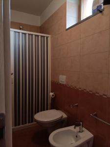 La salle de bains est pourvue de toilettes et d'un lavabo. dans l'établissement Albergo Roma, à Gattico