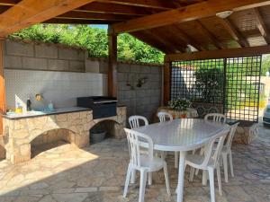 a patio with a table and a stone fireplace at Villa Cycas Costamante in Castellammare del Golfo