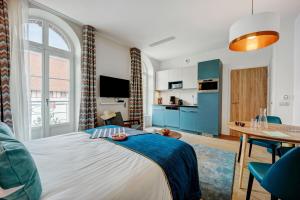 a bedroom with a large bed and a table at Résidence Pierre & Vacances Premium Presqu'Ile de la Touques in Deauville