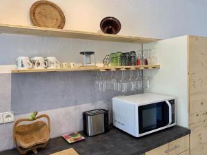 - un four micro-ondes installé au-dessus d'un comptoir dans la cuisine dans l'établissement Ferienwohnung JoSi, à Kappelrodeck
