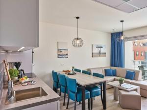 a kitchen and living room with a table and a couch at Holiday Suites Zeebrugge in Zeebrugge