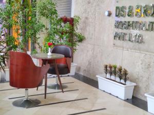 a table and chairs in a room with plants at Hotel DS Clarks Inn Gurgaon in Gurgaon