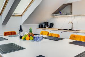 a kitchen with a table with a bowl of fruit at Apartamenty Zdrojowa in Świnoujście