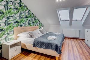 a bedroom with a bed and a wall with plants at Apartamenty Zdrojowa in Świnoujście