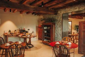 comedor con mesas y sillas y cocina en Hotel Boutique El Mariner en Camprodon