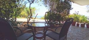 キオスにあるSpacious guesthouse with garden and seaviewのパティオ(テーブル、椅子付) +2枚の写真