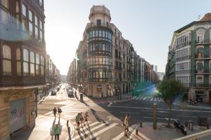 grupa ludzi przechodzących przez ulicę w mieście w obiekcie Bilbao Art Lodge Staynnapartments w mieście Bilbao
