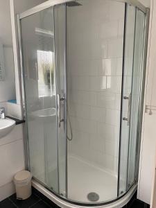 La salle de bains est pourvue d'une douche avec une porte en verre. dans l'établissement 15 Maple Court, à Oxford