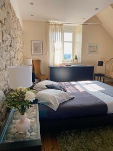 a bedroom with a bed and a vase with flowers on a table at Villa Tourelle in Dinan