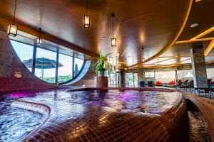 a pool in the middle of a building with purple lights at Allure Healthy Hotel & Spa in Eger