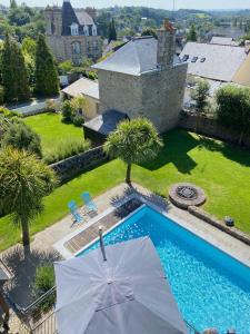 - une vue sur la piscine avec un parasol dans l'établissement Villa Tourelle, à Dinan