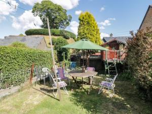 a table and chairs and an umbrella in a yard at Arosfa in Bala