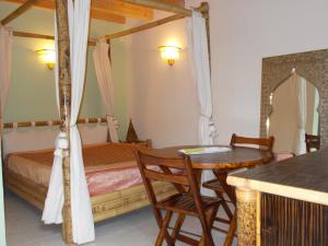 a bedroom with a bed and a table and chairs at Aux Amandiers in Fréjus