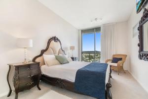 een slaapkamer met een bed en een raam bij Silver Sapphire on Sixth Penthouse in Maroochydore