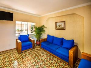 a living room with blue couches and a plant at Hotel La Casa Don Tito in Jocotitlán