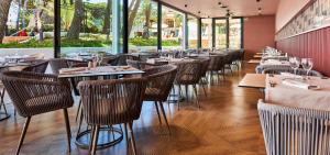 eine Reihe von Tischen und Stühlen in einem Restaurant in der Unterkunft Hotel & Spa S'Entrador Playa in Cala Ratjada