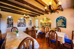 a dining room with tables and chairs and plates on the wall at Hotel La Casa Don Tito in Jocotitlán