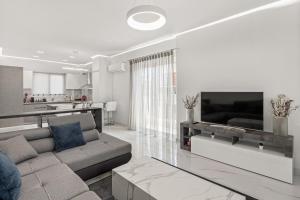 uma sala de estar com um sofá e uma televisão em BillyMare central Glyfada apartment em Atenas