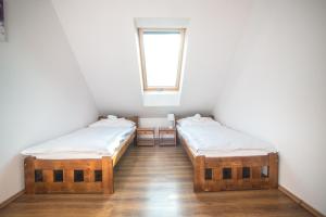 two twin beds in a room with a window at Pataky Apartmanok in Veszprém