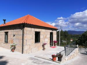 un petit bâtiment en pierre avec un toit orange dans l'établissement Casa dos Matos, à Ponte de Lima