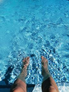 a person with their feet in the blue water at Casa dos Matos in Ponte de Lima