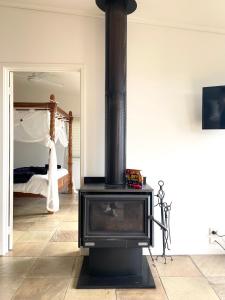 una estufa negra en una habitación con 1 dormitorio en Bali in Mornington Oceanview Villa, en Arthurs Seat