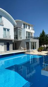 une grande maison avec une piscine en face de celle-ci dans l'établissement Antalya Belek Mermaid Villas 3 Bedrooms close The Beac Park, à Belek