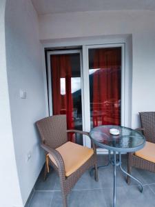 einen Balkon mit einem Tisch und Stühlen sowie einem Fenster in der Unterkunft Apartments KALE in Ohrid