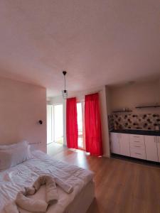 Schlafzimmer mit einem großen Bett und roten Vorhängen in der Unterkunft Apartments KALE in Ohrid